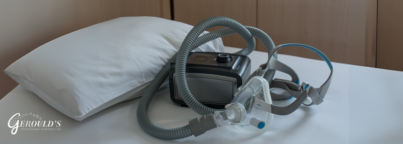 CPAP machine and mask on a bed next to a pillow